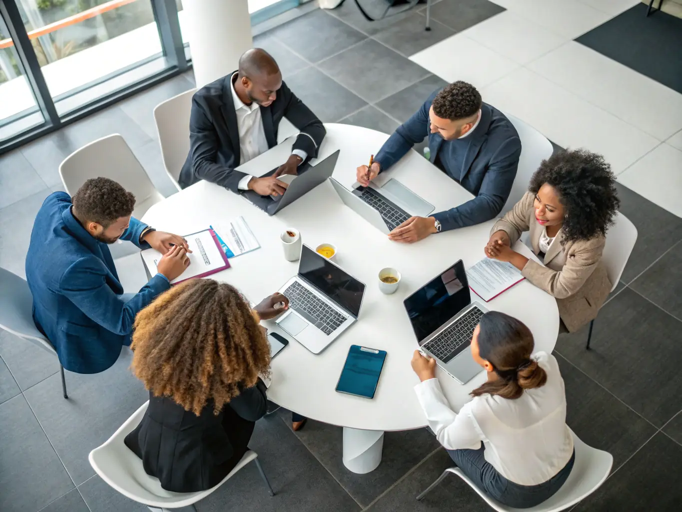 A diverse group of business professionals collaborating around a table, brainstorming ideas and developing innovative solutions, symbolizing the collaborative approach of Bellerstack's coaching.